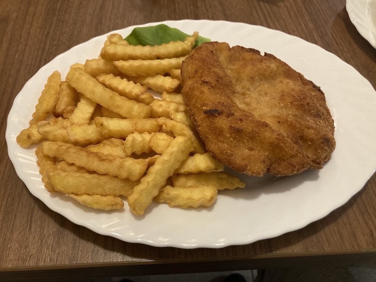 Kotlet schabowy z frytkami podany na białym talerzu w Barze Sylwia